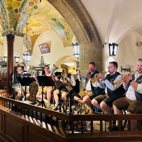 Die Blechpartie spielt sitzend auf der Musikantenbühne unter dem bemalten Gewölbe