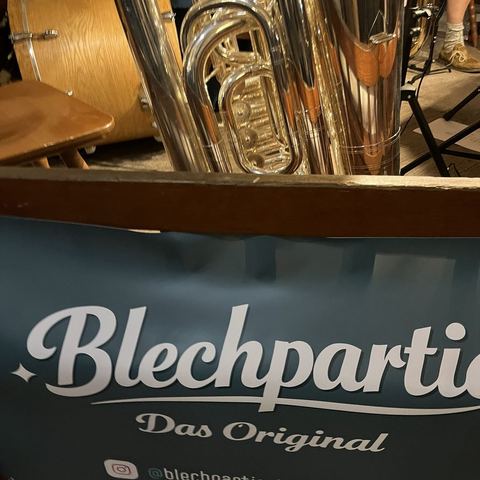 Tuba hinter dem Blechpartie-Banner