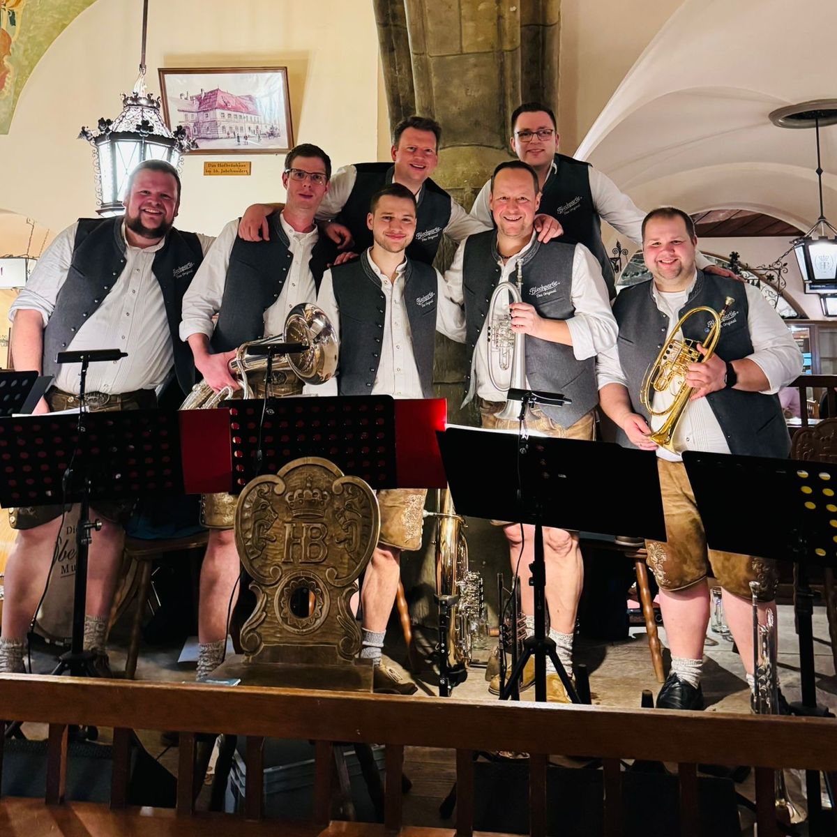Gruppenfoto der Blechpartie in Tracht im Gewölbe eines Wirtshauses